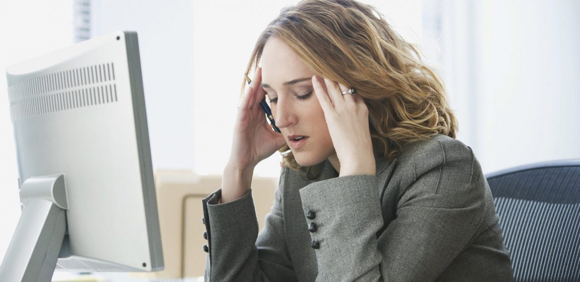 Mulher estressada em frente ao seu computador no trabalho